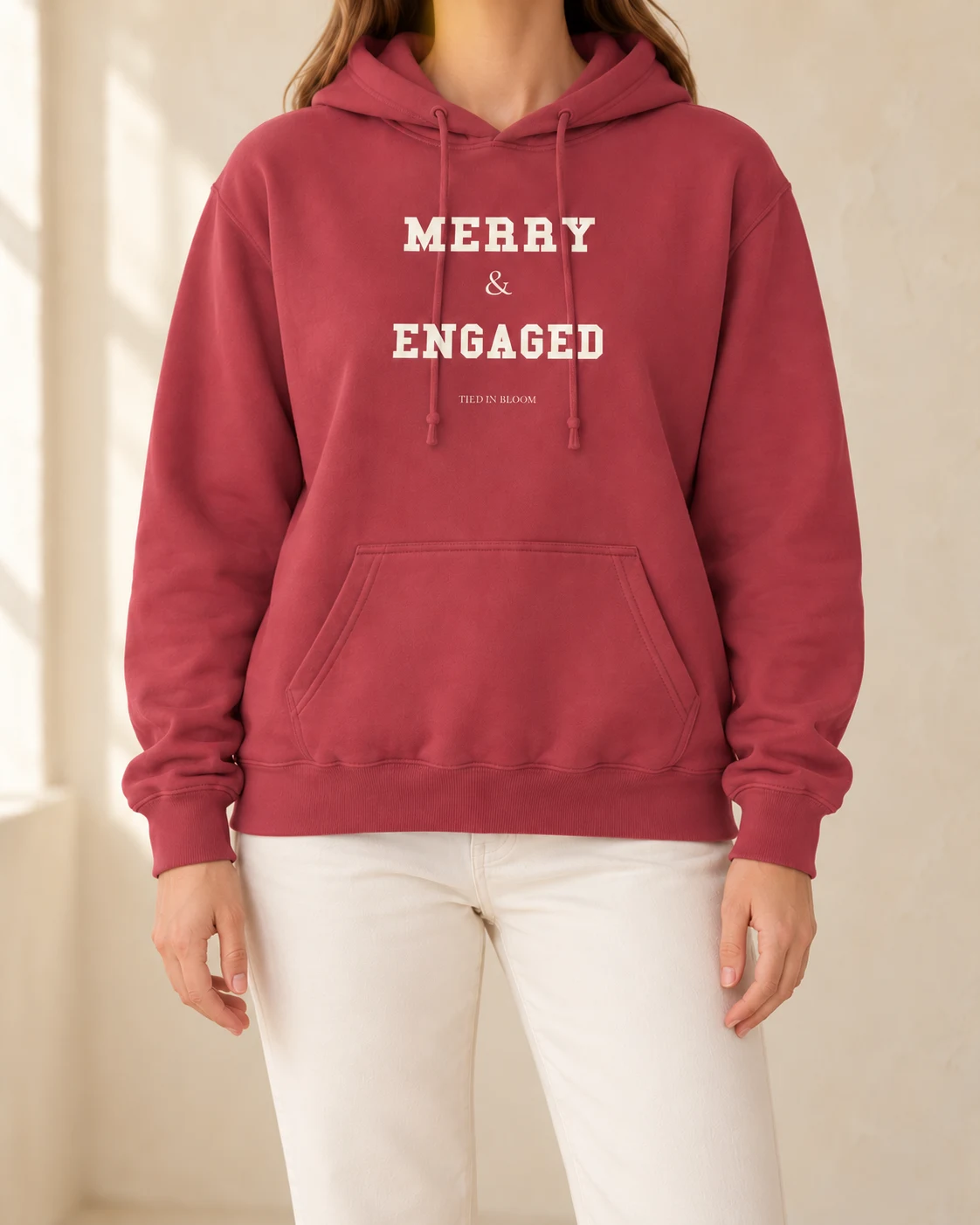 AI mockup of a woman wearing Merry & Engaged Hoodie in Crimson, cropped below the face.