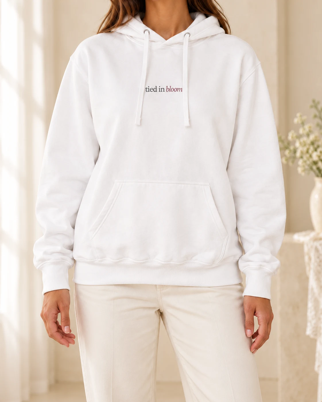 AI mockup of a woman wearing The Quiet Bloom Hoodie in White, cropped below the face.